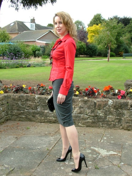 Fully clothed woman steps out of a stiletto heel while visiting a public park 71546058
